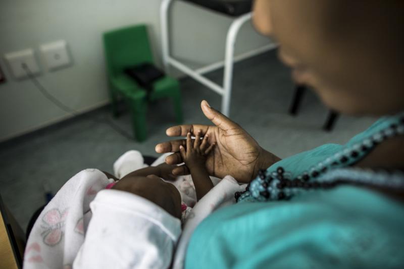 Health workers at Shanamutango HIV clinic at Onandjokwe Hopsital in Namibia consult with an HIV-positive client after the birth of her HIV-negative baby. Photo by Morgana Wingard for IntraHealth International.