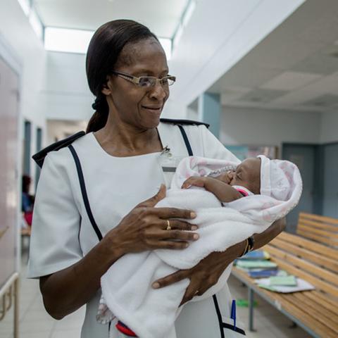 Nurse Ruusa Shipena holds an HIV-negative baby at Onandjokwe Hospital, Namibia. Photo by Morgana Wingard for IntraHealth International.