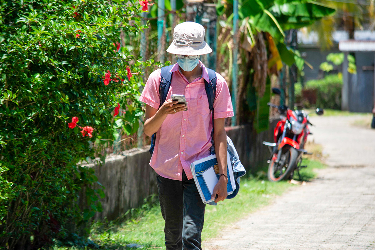 A health worker checks their phone on the way to visit HIV-positive clients in Livingston Izabal, Guatemala. Photo by Levi Dieguez for IntraHealth International.